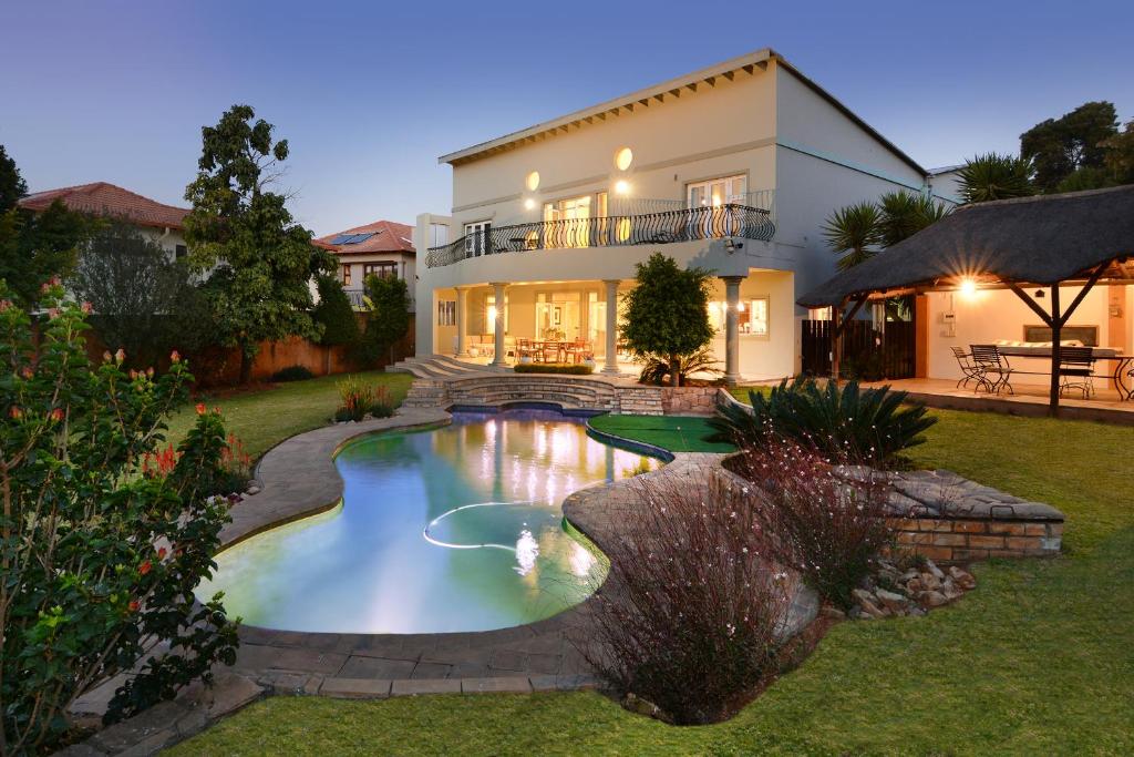 una casa con piscina frente a una casa en Sandown Guest House en Johannesburgo