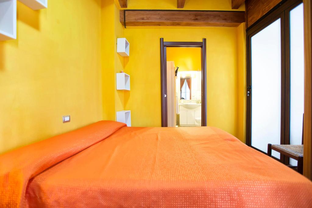 1 dormitorio con 1 cama grande en una habitación amarilla en Affittacamere Zahra, en Alghero