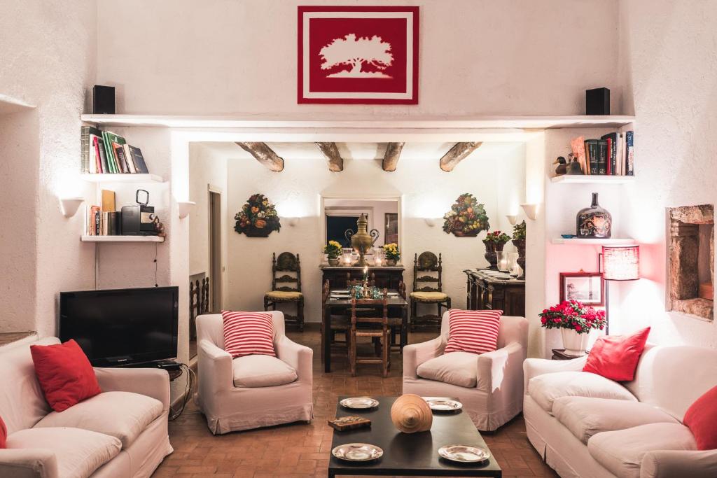 a living room with white couches and a tv at Borgo degli Ulivi in Porto Ercole