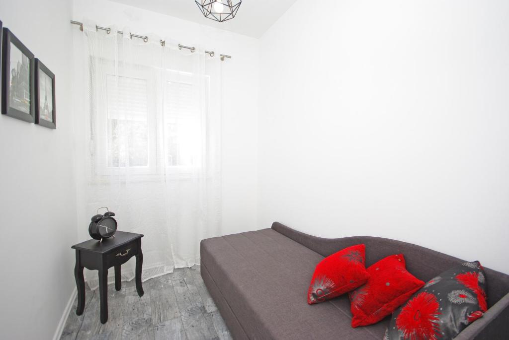 a bedroom with a couch with red pillows and a table at "NM" Luxury apartments in Split