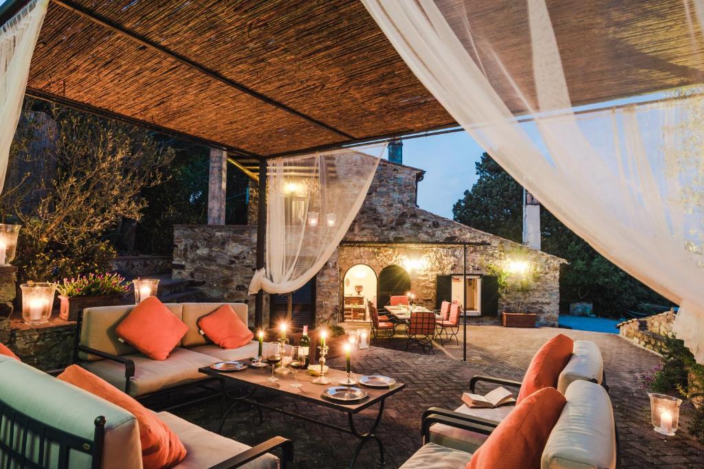 um pátio exterior com mobiliário e uma lareira de pedra em Borgo degli Ulivi em Porto Ercole