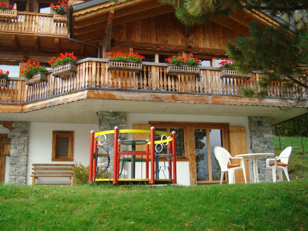 a house with a balcony with a table and chairs at Chalet Hestia in Champéry