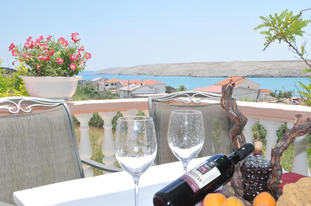 a table with two glasses of wine on a balcony at Apartment Zdenka in Dinjiška