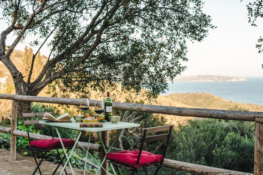 a table with a bottle of wine and a book at Borgo degli Ulivi in Porto Ercole