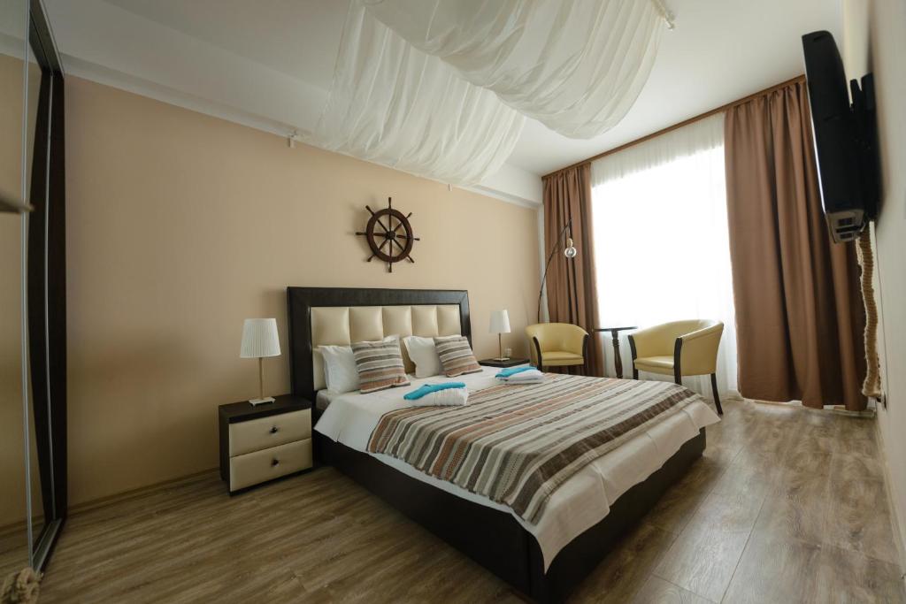 a bedroom with a large bed and a large window at Velier Apartment in Mamaia
