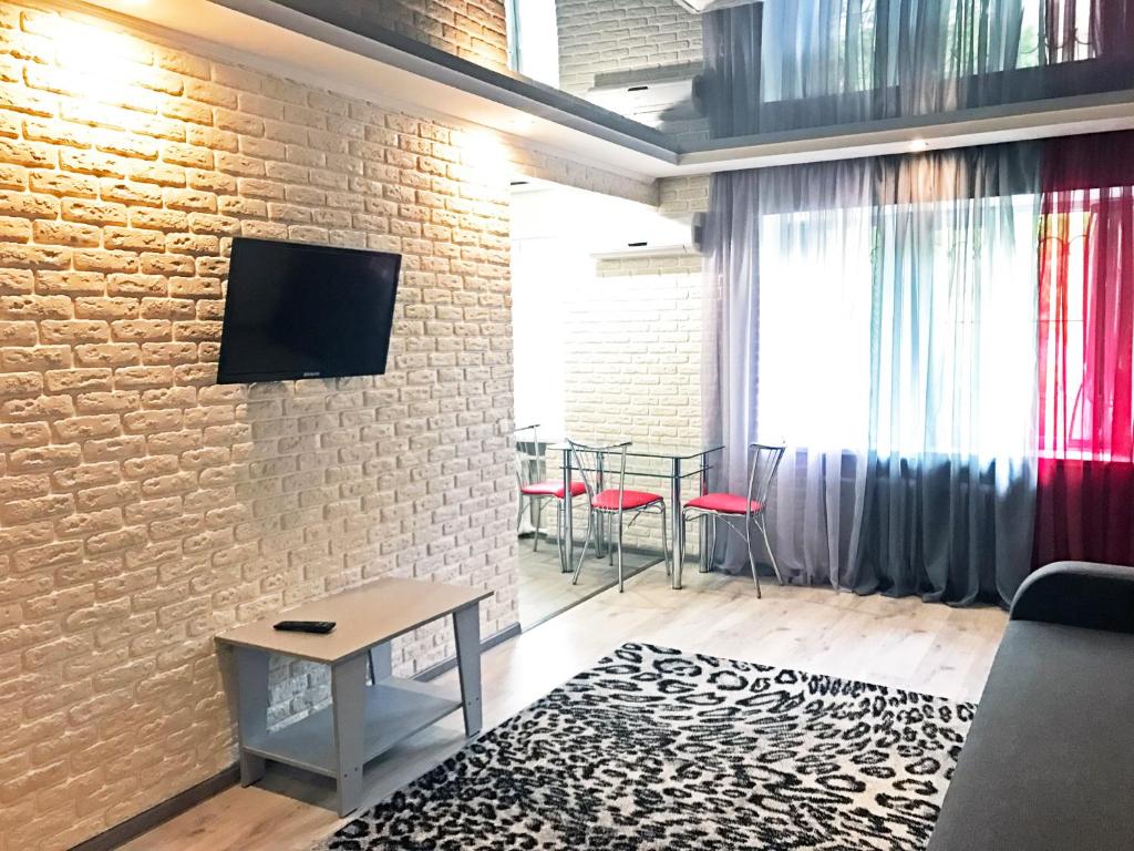 a living room with a tv on a brick wall at Apartment on Pushkina (Prospect Soborniy) in Zaporozhye