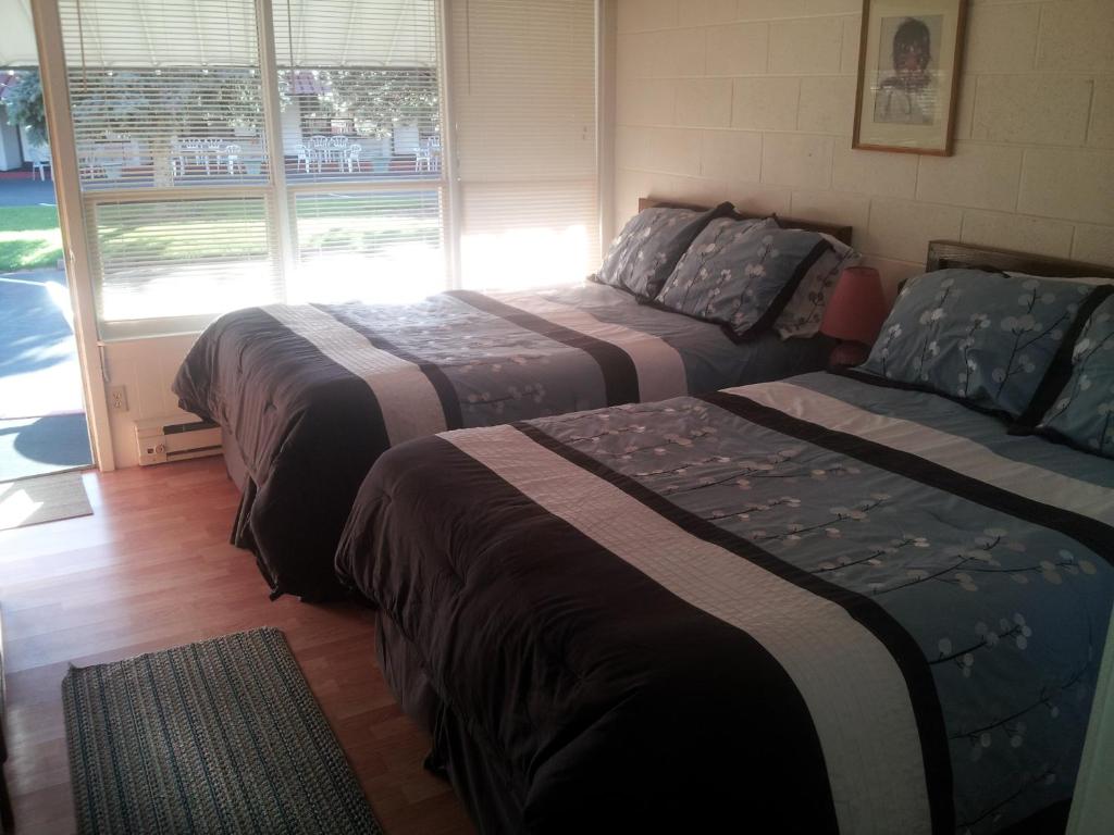 2 camas en una habitación con ventana en Capricorn Motel Royale 1000 Islands, en Lansdowne