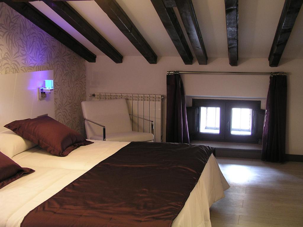 A bed or beds in a room at Hotel Rural Villa de Berlanga