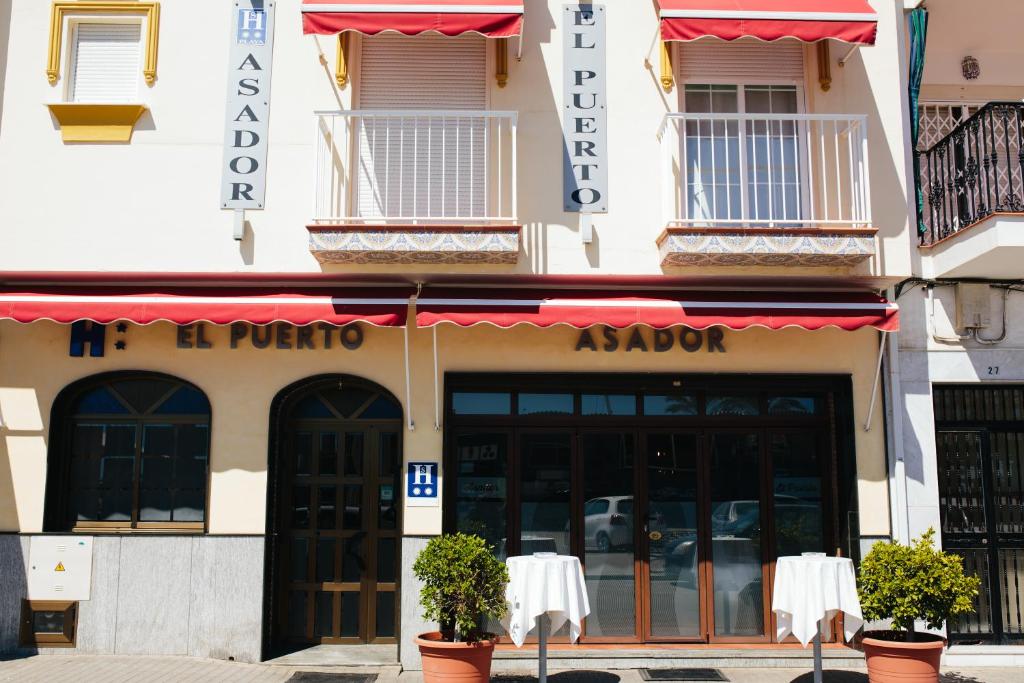 a restaurant with two tables in front of a building at Hostal El Puerto in Caleta De Velez