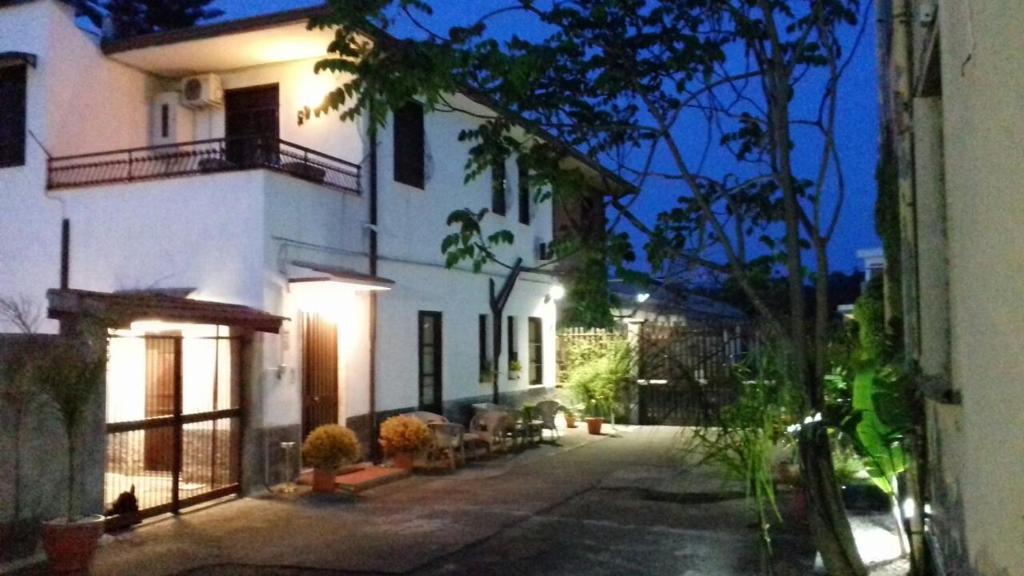 un gran edificio blanco con luces en una calle en Bed & Breakfast Fontanarossa Airport -Private Parking-, en Catania