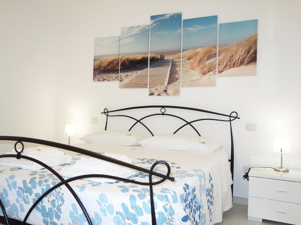 a bedroom with a bed and a boardwalk on a beach at La Baia Apartments in Torre Lapillo