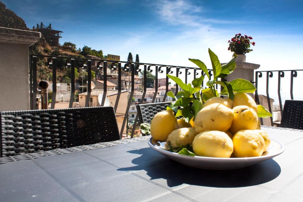 a bowl of lemons on a table on a balcony at Casa Corvaja in Taormina