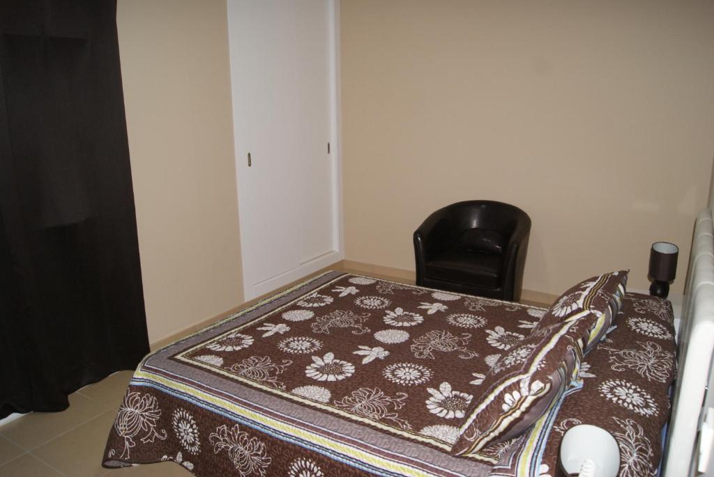 a bed with a blanket on a table with a chair at Hotel Doña Luisa in San Luis de Sabinillas