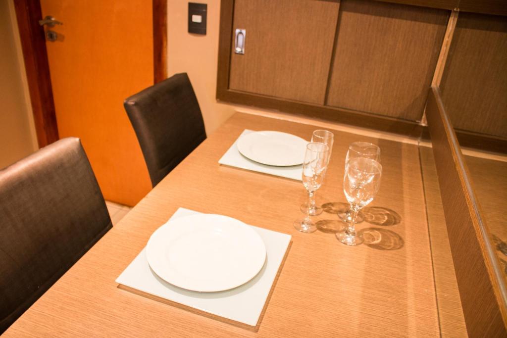 einen Tisch mit weißen Tellern und Weingläsern darauf in der Unterkunft Platinum Motel (Adults Only) in Fortaleza