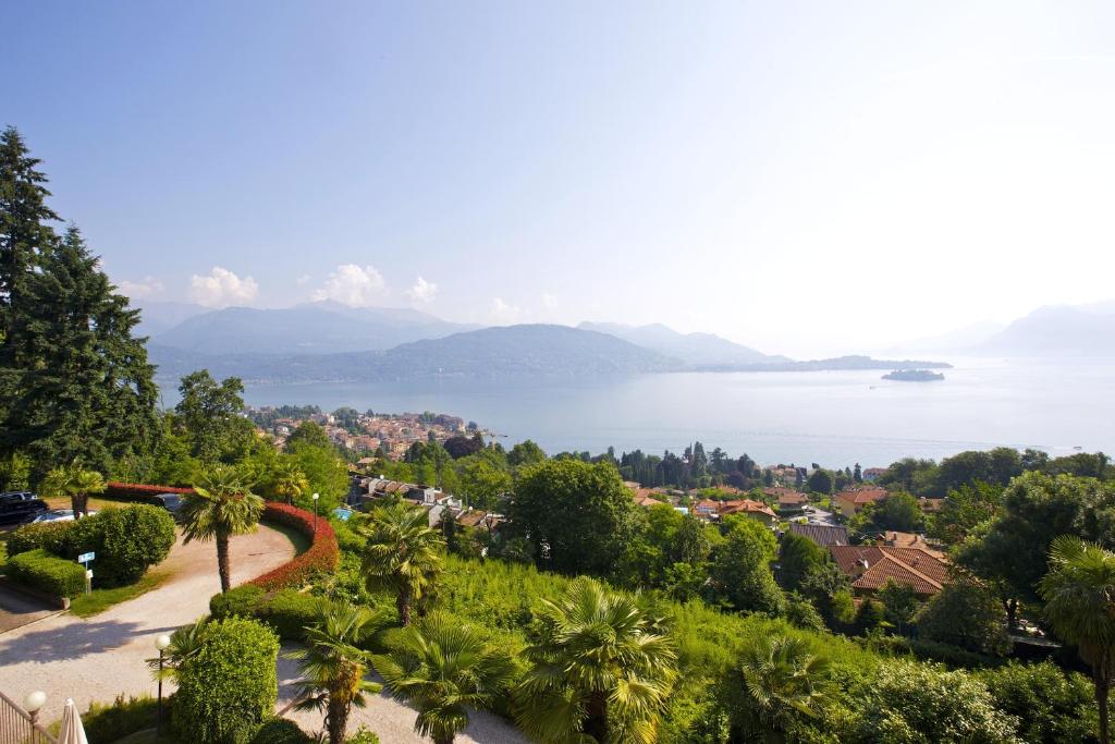 Blick auf die Stadt und einen See mit Palmen in der Unterkunft Villa Anna Isole Borromee in Baveno