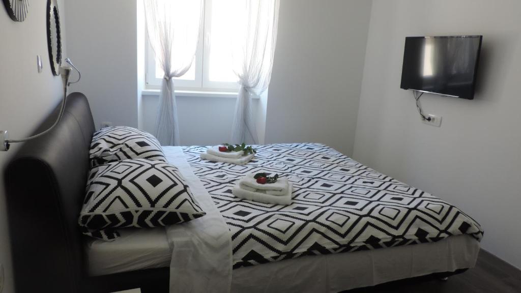 a bedroom with a bed with two shoes on it at Apartment & room Ivan in Šibenik