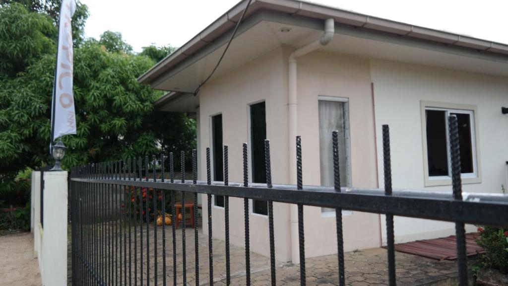 a black fence in front of a house at Tropico Inn in Paramaribo
