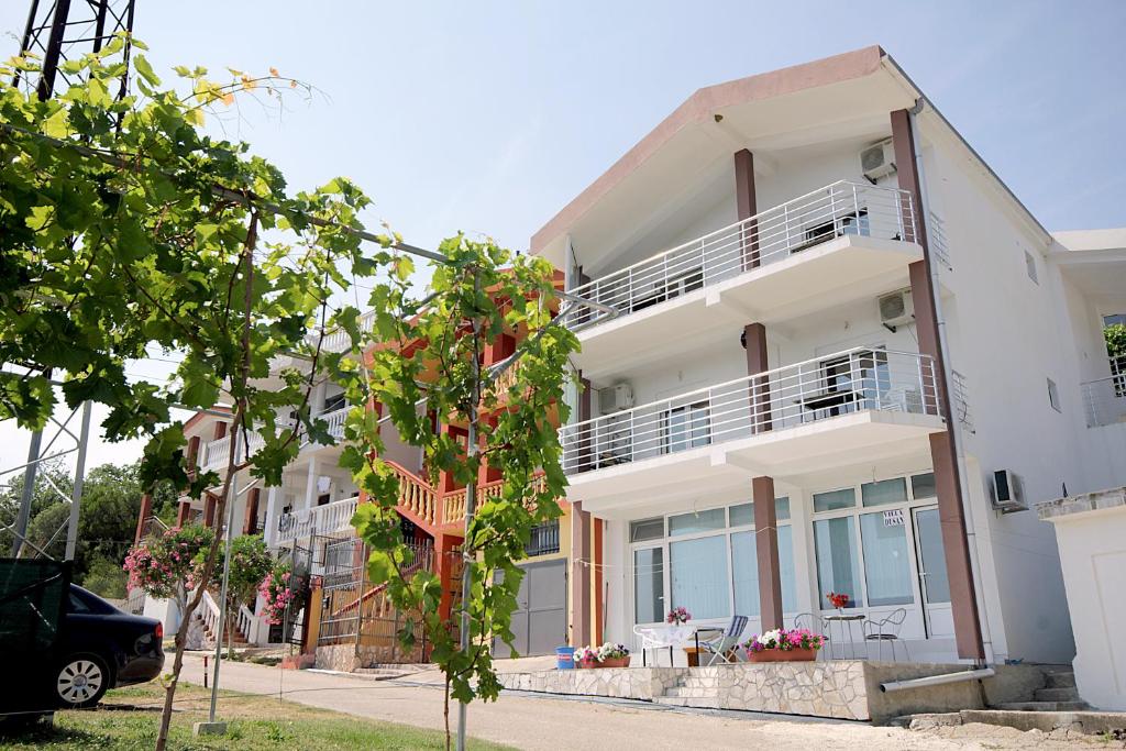 een wit appartementencomplex met een balkon bij Apartments Vila Dusan in Sutomore