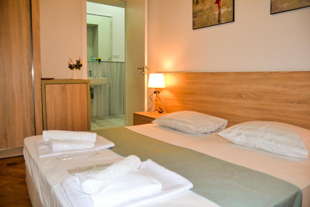 sypialnia z 2 łóżkami i białymi ręcznikami w obiekcie Piccolo Casa Bella Hotel w mieście Tbilisi City