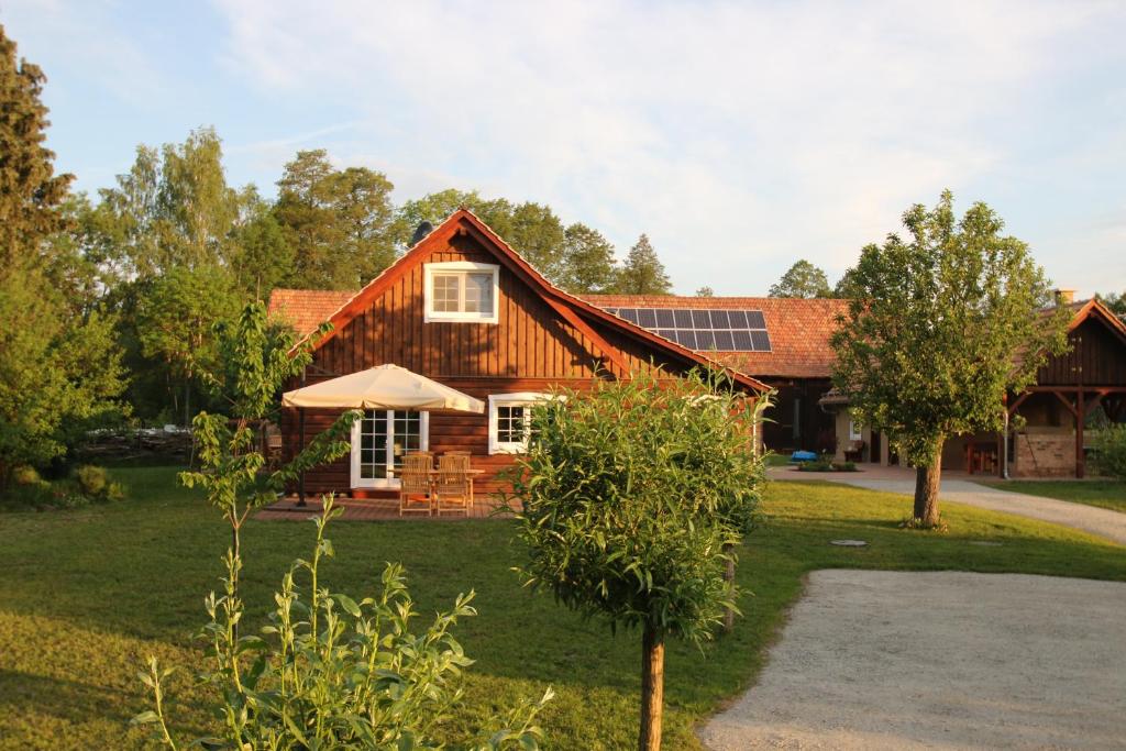 una casa de madera con un árbol delante de ella en Grüne Farm - FeWo Ost, en Burg Kauper