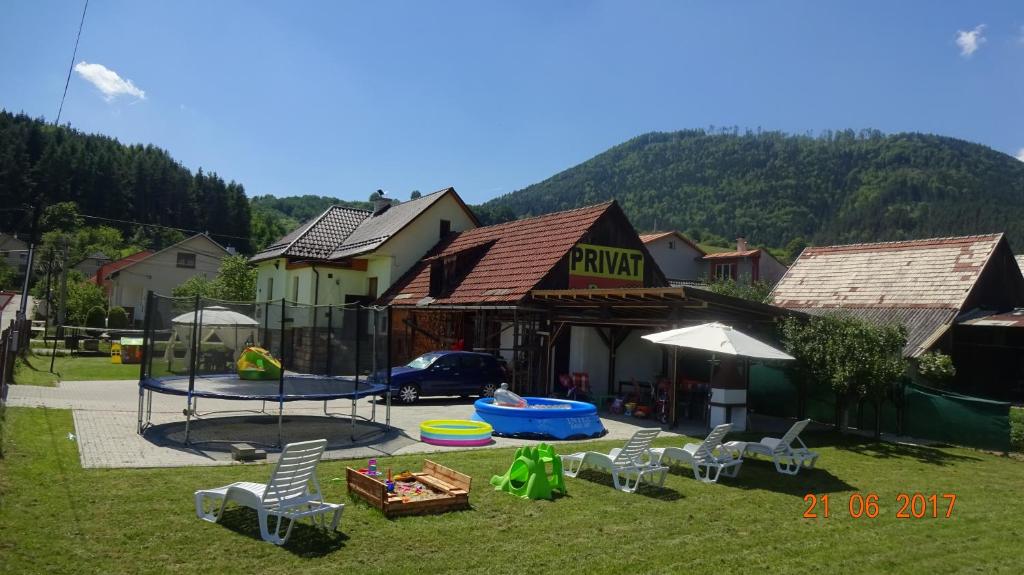 a yard with chairs and a pool in front of a building at Apartmán u Benkov in Lúčky