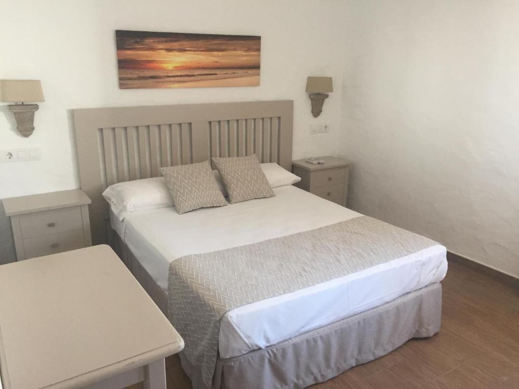 a small bedroom with two beds and a table at Hotel Almadrabeta in Zahara de los Atunes