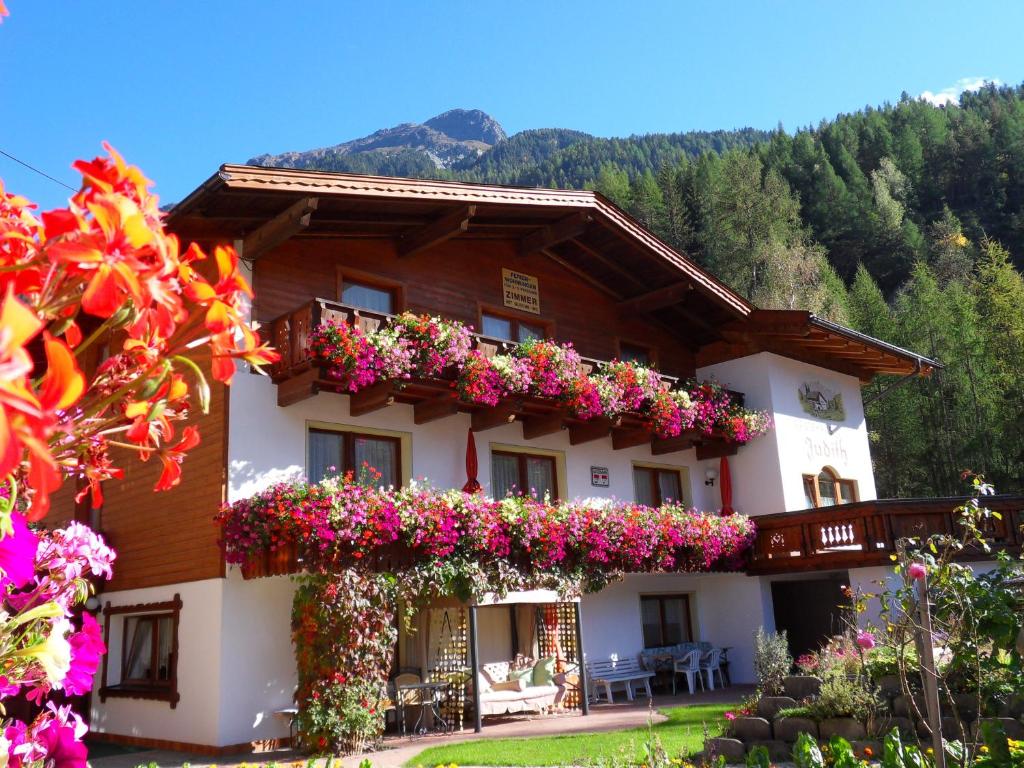 ein Gebäude mit Blumen auf der Seite in der Unterkunft Gästehaus Judith in Längenfeld