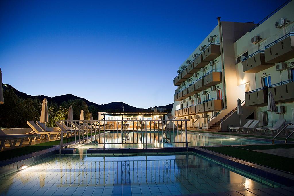 un hôtel avec une piscine en face d'un bâtiment dans l'établissement Hotel Athinoula, à Kefalos