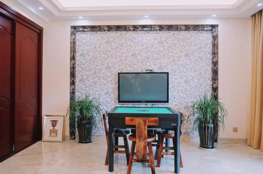 una camera con una scrivania, una TV e 2 sedie di The Zhang B&B a Tiantai