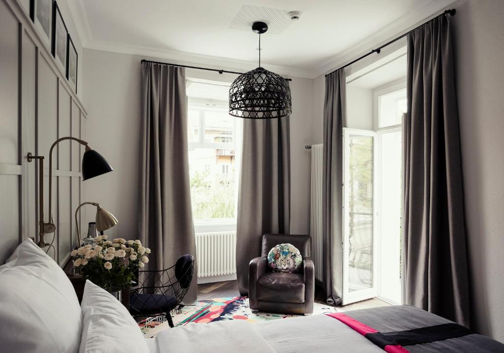 a bedroom with a bed and a chair and a window at Kollmann Rooms and Apartments in Ljubljana