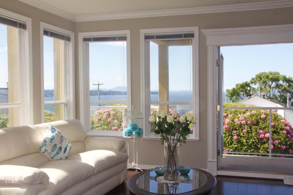ホワイトロックにあるStar of the Sea guest houseのリビングルーム(ソファ付)、花の咲く窓