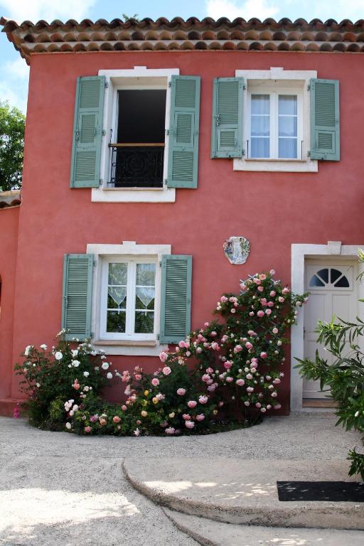 une maison rouge avec des fenêtres à volets verts et des fleurs dans l'établissement Lou Pero Mousco, à Saint-Paul-en-Forêt