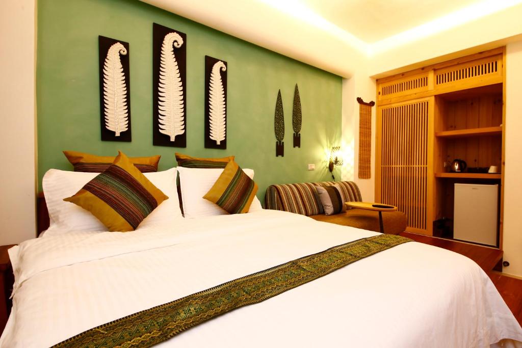 1 dormitorio con 1 cama blanca grande con espejos en la pared en Tang Chao B&B en Jiaoxi