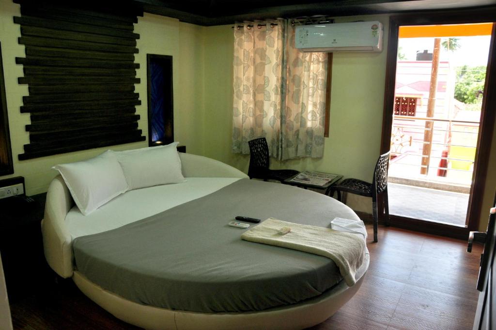 Postel nebo postele na pokoji v ubytování Hotel Anandhiram Heritage