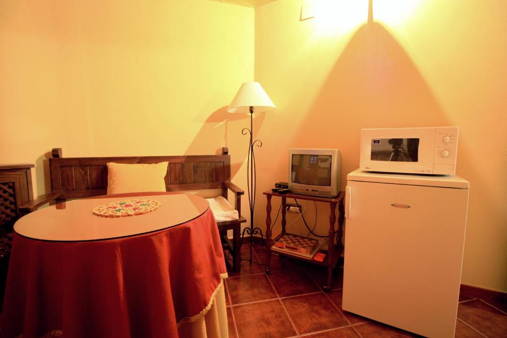 Habitación con cama con microondas y mesa en La Boticaria Casa Rural Apartamento, en Descargamaría
