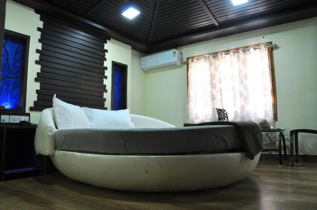 Postel nebo postele na pokoji v ubytování Hotel Anandhiram Heritage