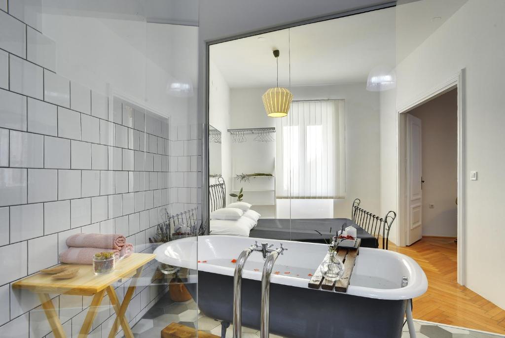 a bathroom with a tub and a large mirror at Apartments Forum in Pula