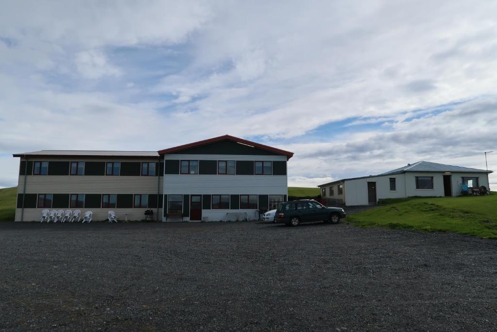 a building with a car parked in front of it at Hvoll Hostel in Kirkjubæjarklaustur