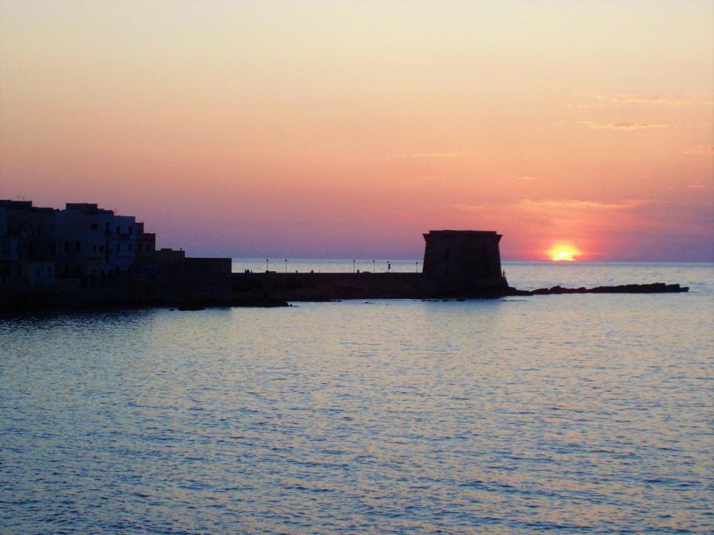 a sunset over a body of water with a building at Bed and Breakfast Sapore di Sale in Trapani