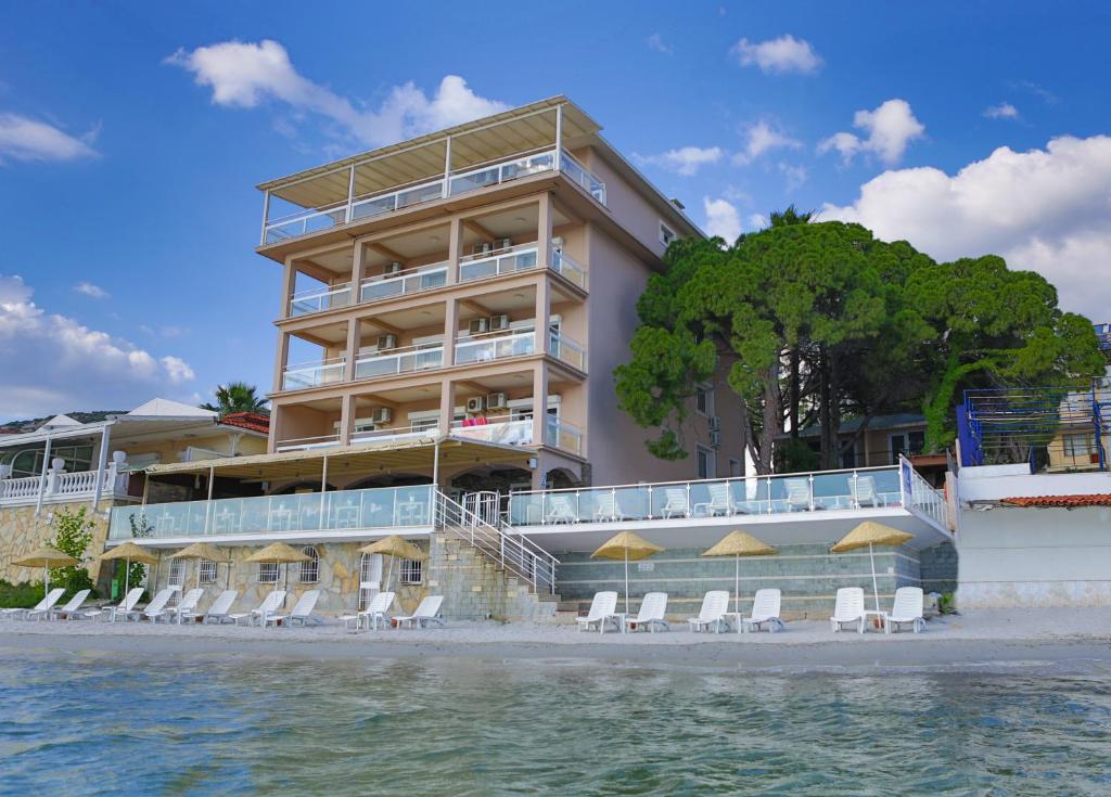 クシャダスにあるMelis Hotel Kusadasiのビーチのホテルで、椅子と水を用意しています。