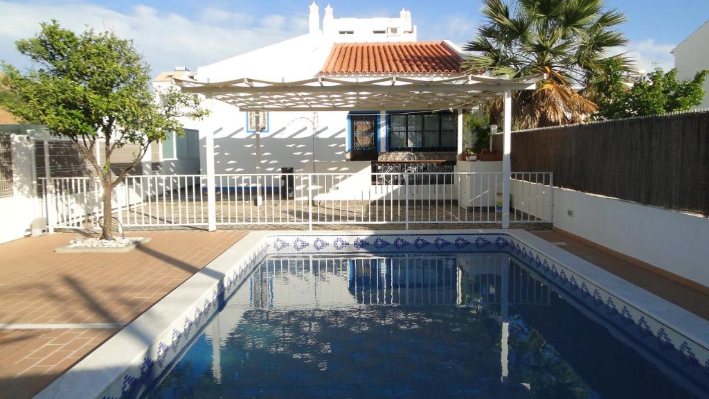 a swimming pool with a gazebo next to a house at Pérola do Oceano in Manta Rota