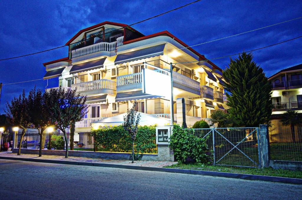 ein großes weißes Gebäude mit Lichtern an der Straßenseite in der Unterkunft John & Eve Hotel in Paralia Katerinis
