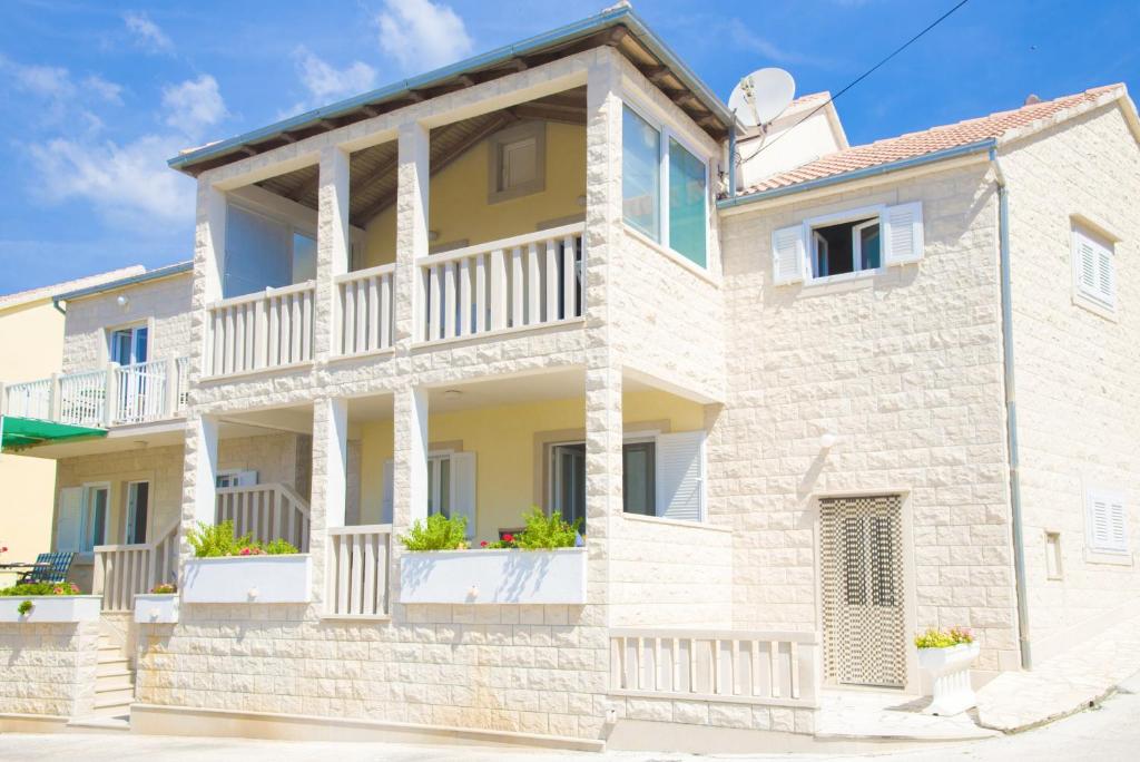 a large white house with a balcony at Eni apartments BOL in Bol