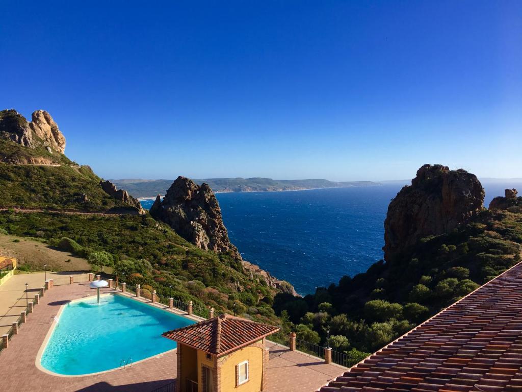 a view of the ocean from a resort with a swimming pool at Il Dolce Risveglio Tanca Piras in Nebida