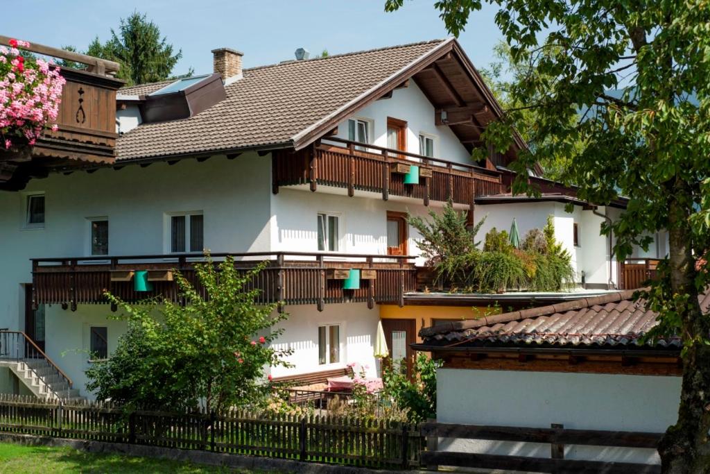 ein großes weißes Haus mit Holzbalkonen und Bäumen in der Unterkunft Appartements Pungg in Fügen