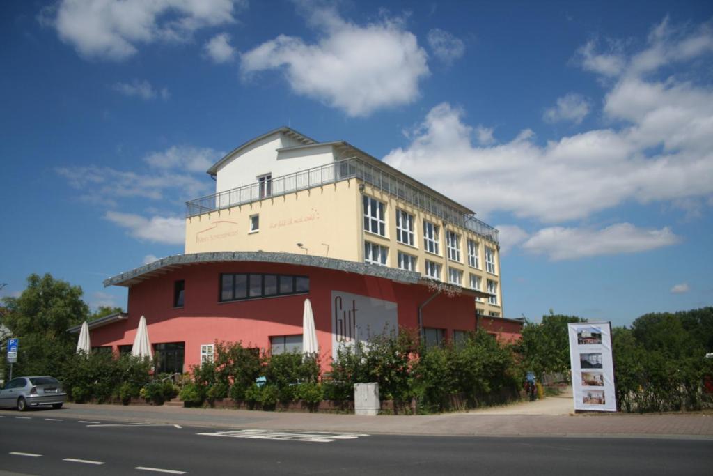 un edificio rojo y blanco al lado de una calle en Mein SchlossHotel, en Heusenstamm