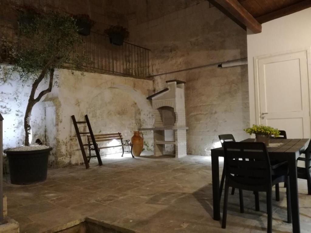 マテーラにあるSassi Sotto Le Stelleのテーブルと椅子、暖炉が備わる客室です。