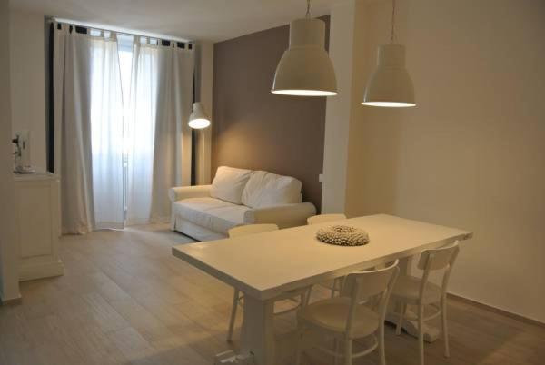 un soggiorno con tavolo, sedie e divano di Piano B Apartment a Trento