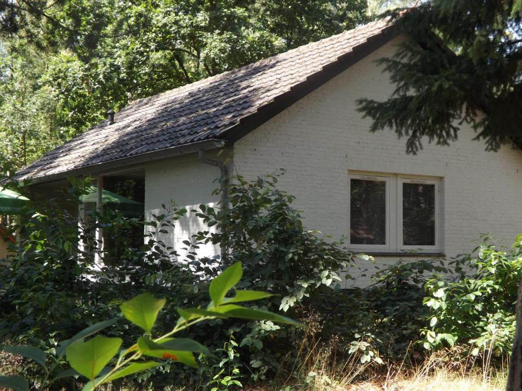 una pequeña casa blanca con techo de gambrel en Vosseven 32 Geelgors en Stramproy