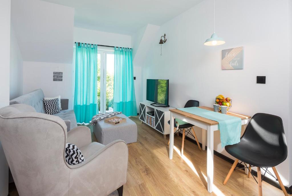 een woonkamer met een tafel en stoelen bij Apartament Zeglarski in Powidz